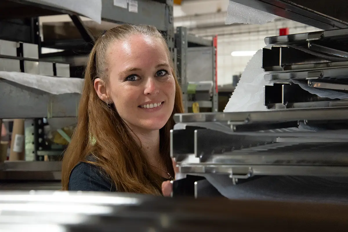 DTS Employee Heather checking inventory and smiling to camera
